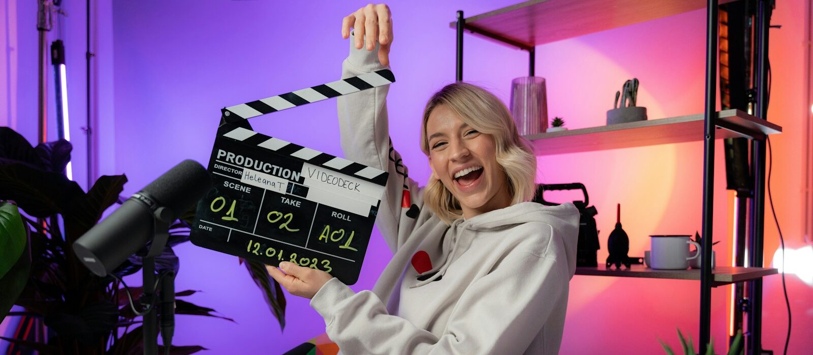 Femme dans un studio de podcast tenant un clap vidéo